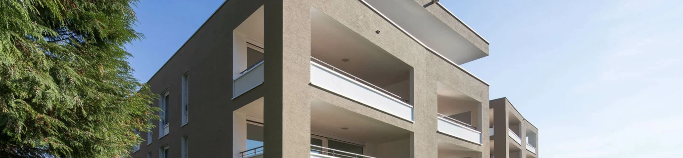 Wohnanlage Widum Lustenau 1 mit brauner Fassade und weißen Balkonen