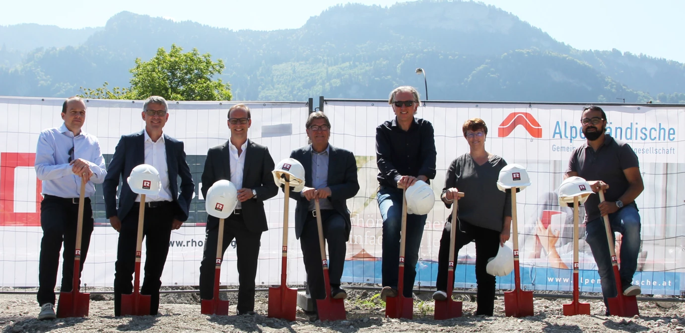 Gruppenbild mit Spaten: Christian Jauk und Martin Summer von Rhomberg Bau, Bürgermeister Dieter Egger, AH-Geschäftsführer Ing. Wilhelm Muzyczyn, Architekt DI Reinhard Drexel, Alexandra Schalegg von der Alpenländischen sowie Rhomberg-Bauleiter Gökhan Ülker feierten bei strahlendem Sonnenschein den Baustart der Wohnanlage in der Wasenstraße.