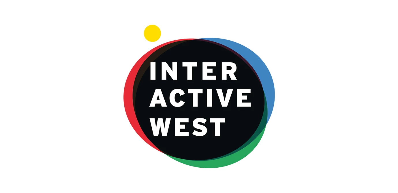 Logo mit den Wörtern INTERACTIVE WEST in weiß auf schwarzem Kreis, umrandet von roten, blauen und grünen überschneidenden Kreisen und einem gelben Punkt.