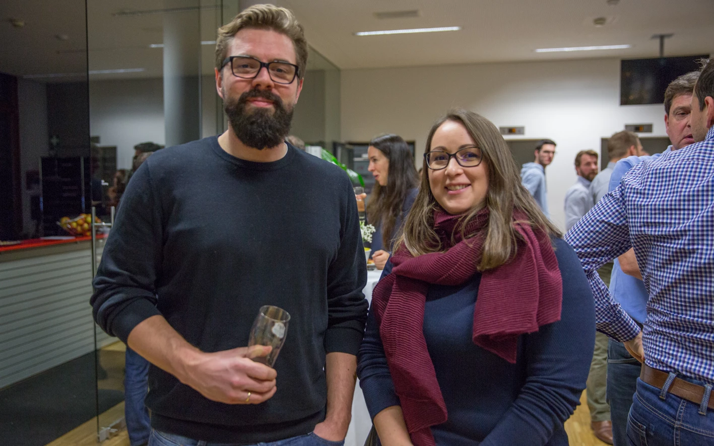 Ein bärtiger Mann mit Brille und ein Lächeln einer Frau mit Schal und Brille bei einer Feier (Hubert, Geburtstag).