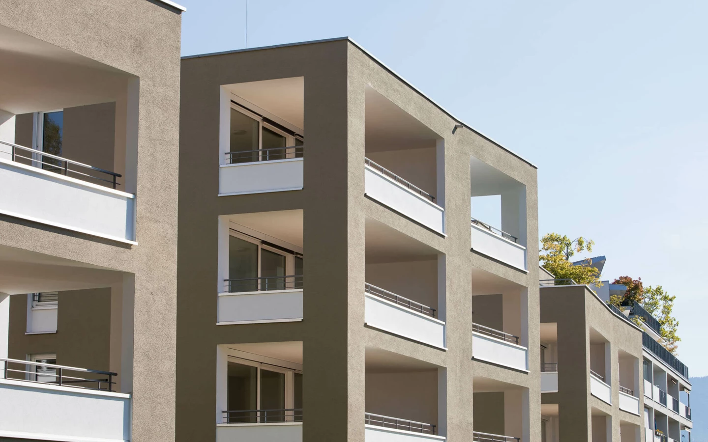 Fassade einer modernen Wohnanlage in Lustenau mit mehreren Balkonen und Fenstern (Widum)