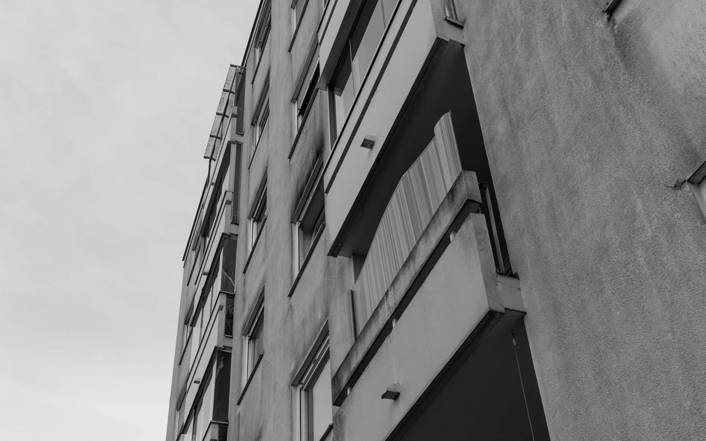 Blick von unten auf ein altes Mehrfamilienhaus an der Römerstraße mit Balkonen und Fenstern