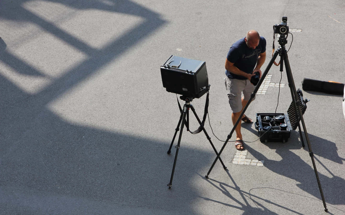 Ein Fotograf stellt seine Ausrüstung, einschließlich Kamera und Stativ, für ein Fotoshooting im Freien auf.