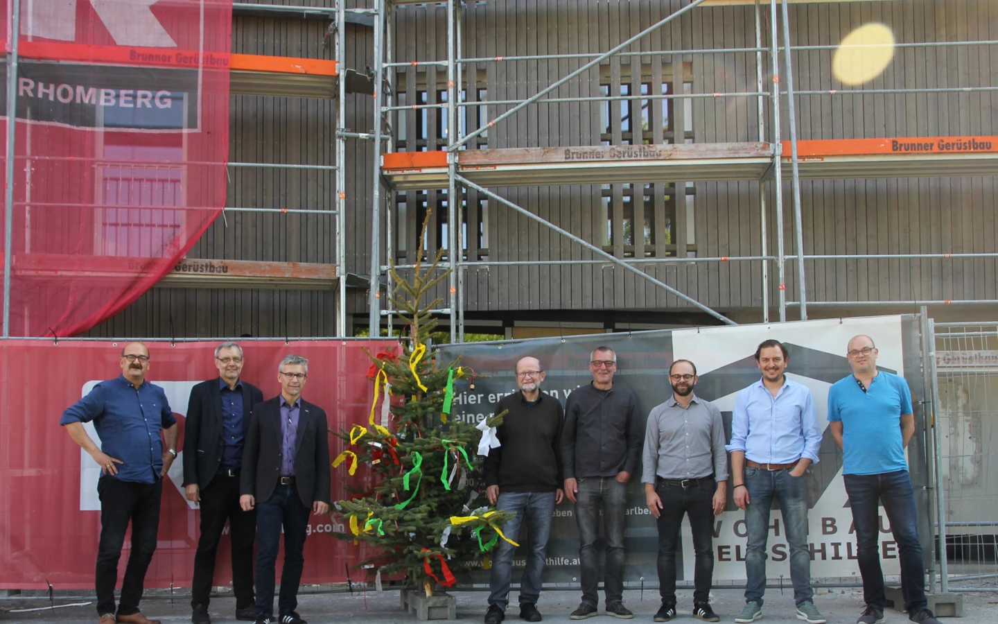 Gruppenbild mit Firstbaum: Die Verantwortlichen von Wohnbauselbsthilfe, Rhomberg Bau, Gemeinde und Architekt bei der Gleichenfeier in Dornbirn.