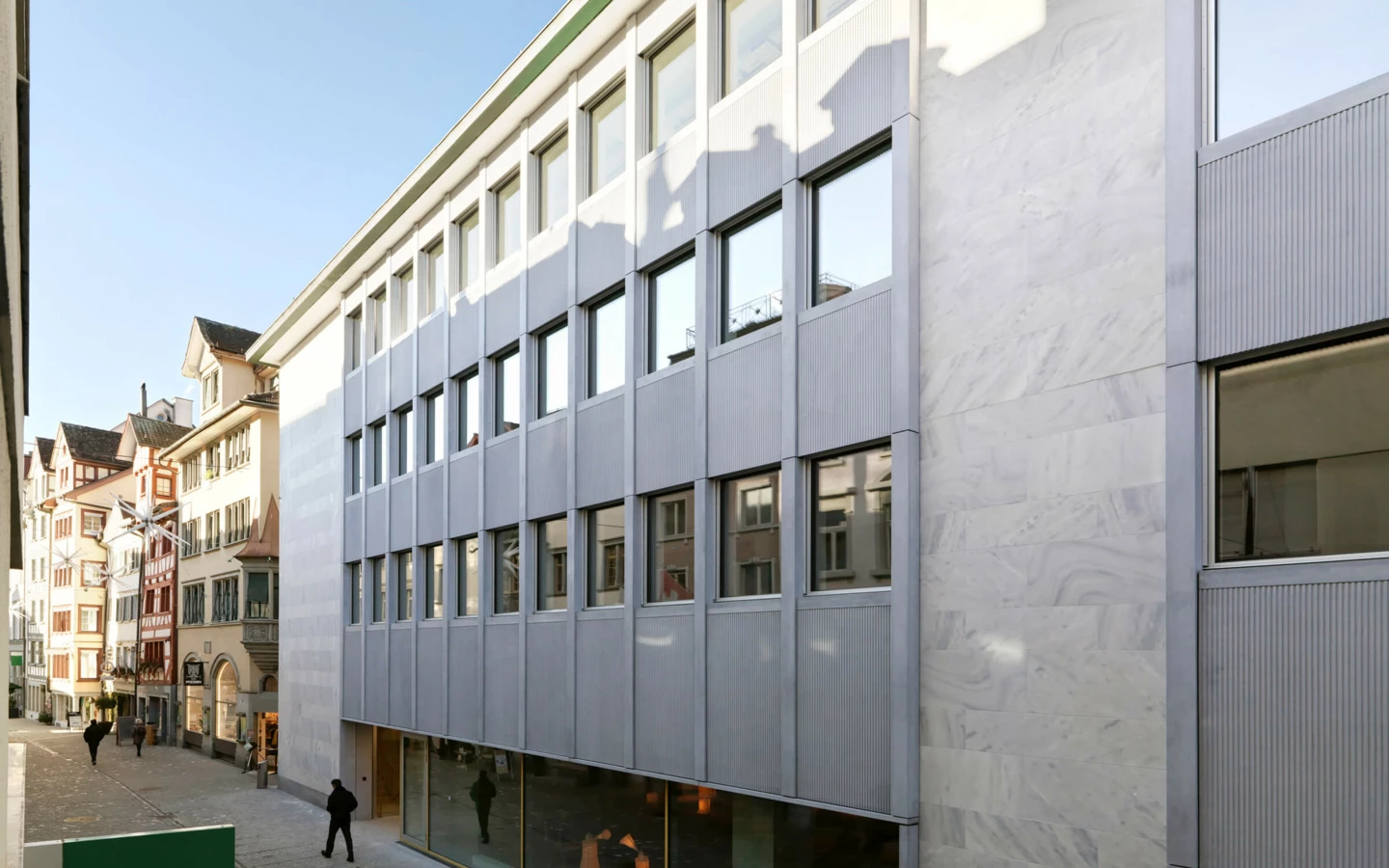 Die Außenansicht der sanierten Multergasse 11-17 in St. Gallen, mit modernem Fassadendesign und grossen Fenstern.