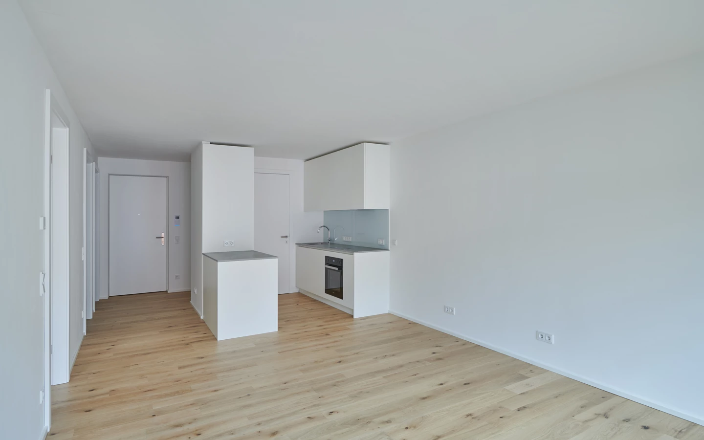 Eine moderne, helle Wohnung mit offener Küche und Holzboden in der Apollogasse.