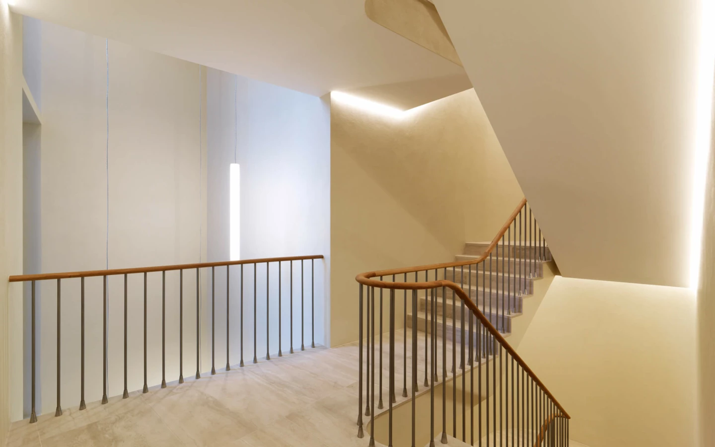 Modernes Treppenhaus mit Marmorboden, eleganten Holz-Handläufen und indirekter LED-Beleuchtung in St. Gallen (Multergasse).
