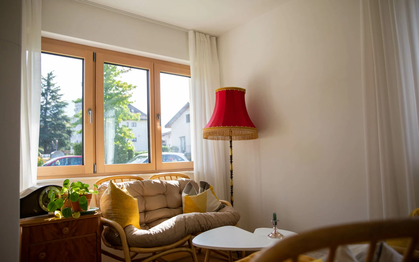 Helles Wohnzimmer mit Holztisch, Pflanzen und Blick aus dem Fenster (Generalsanierung, Einfamilienhaus, Dornbirn)