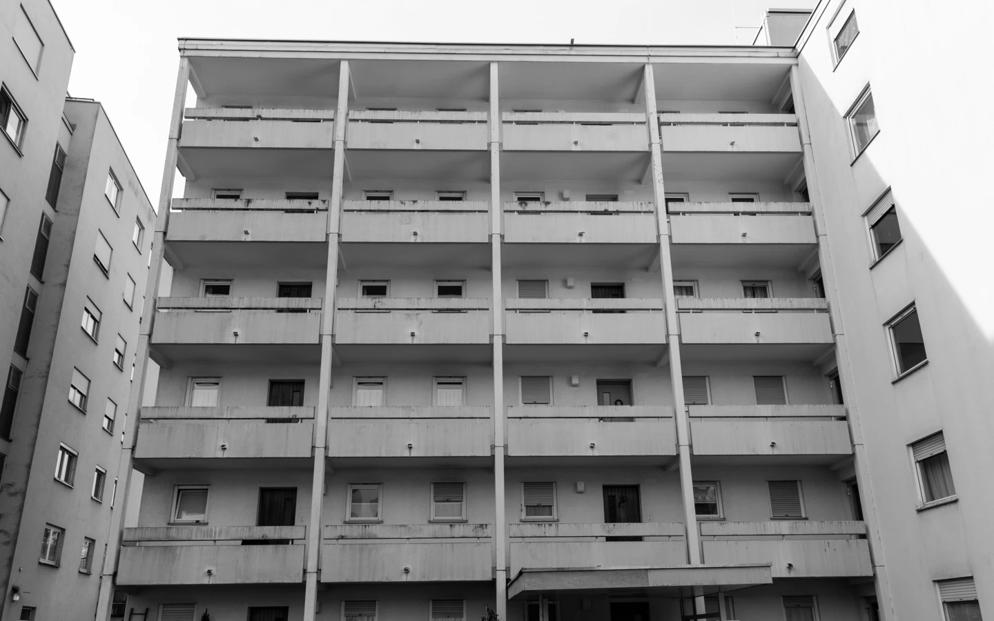 Eine Schwarz-Weiss-Aufnahme des mehrstöckigen Wohnhauses an der Römerstraße mit Balkonen und Fenstern