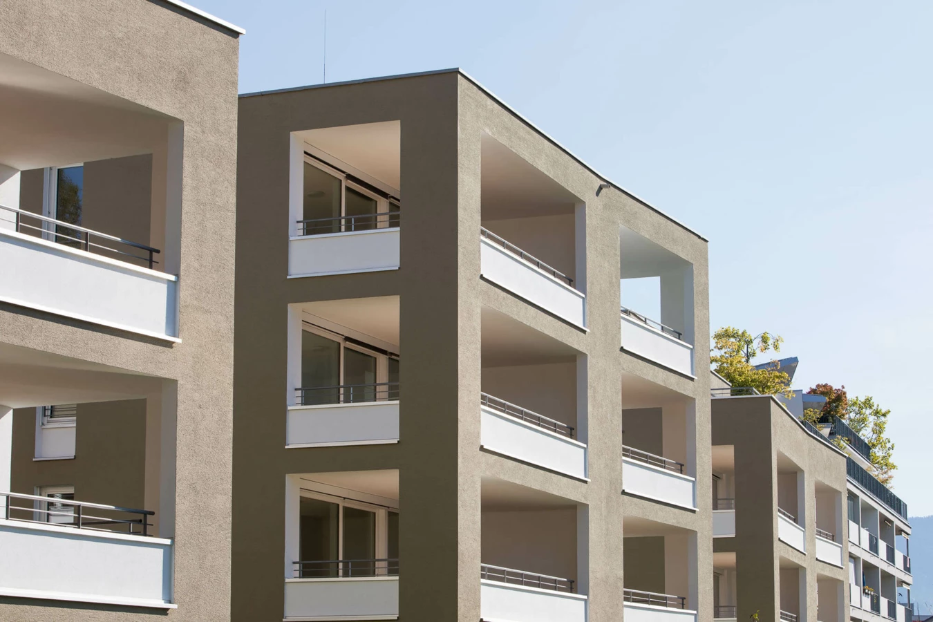 Fassade einer modernen Wohnanlage in Lustenau mit mehreren Balkonen und Fenstern (Widum)