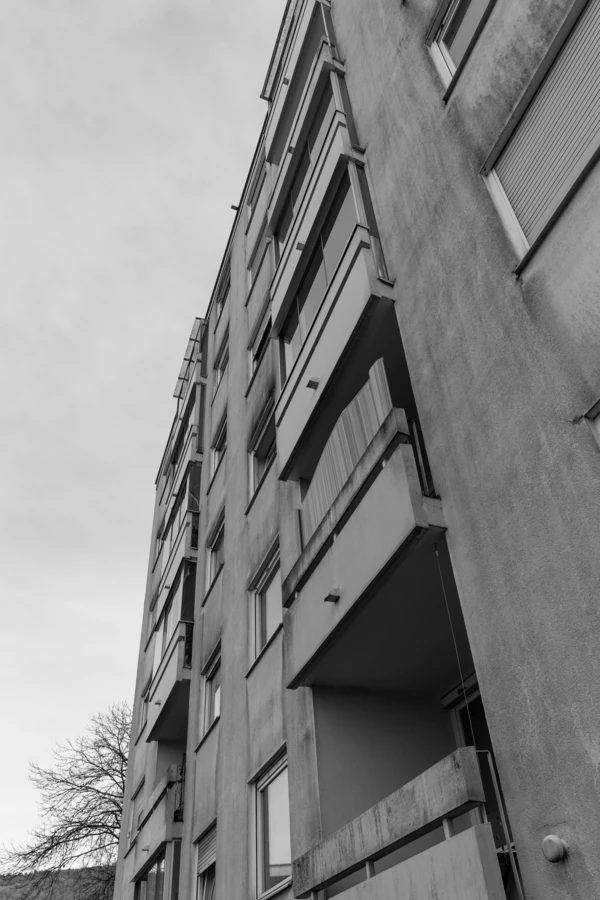 Blick von unten auf ein altes Mehrfamilienhaus an der Römerstraße mit Balkonen und Fenstern