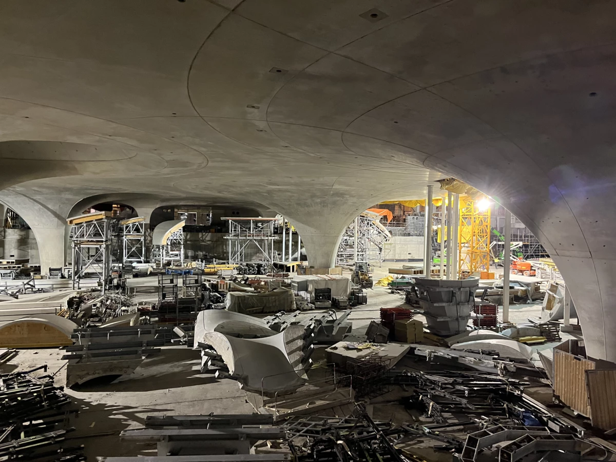 Eine große Baustelle mit gewölbten Betondecken, Baugerüsten und verschiedenen Baumaterialien. Kräne und Baugeräte sind im Hintergrund zu sehen (Rankweil, Deutschland).