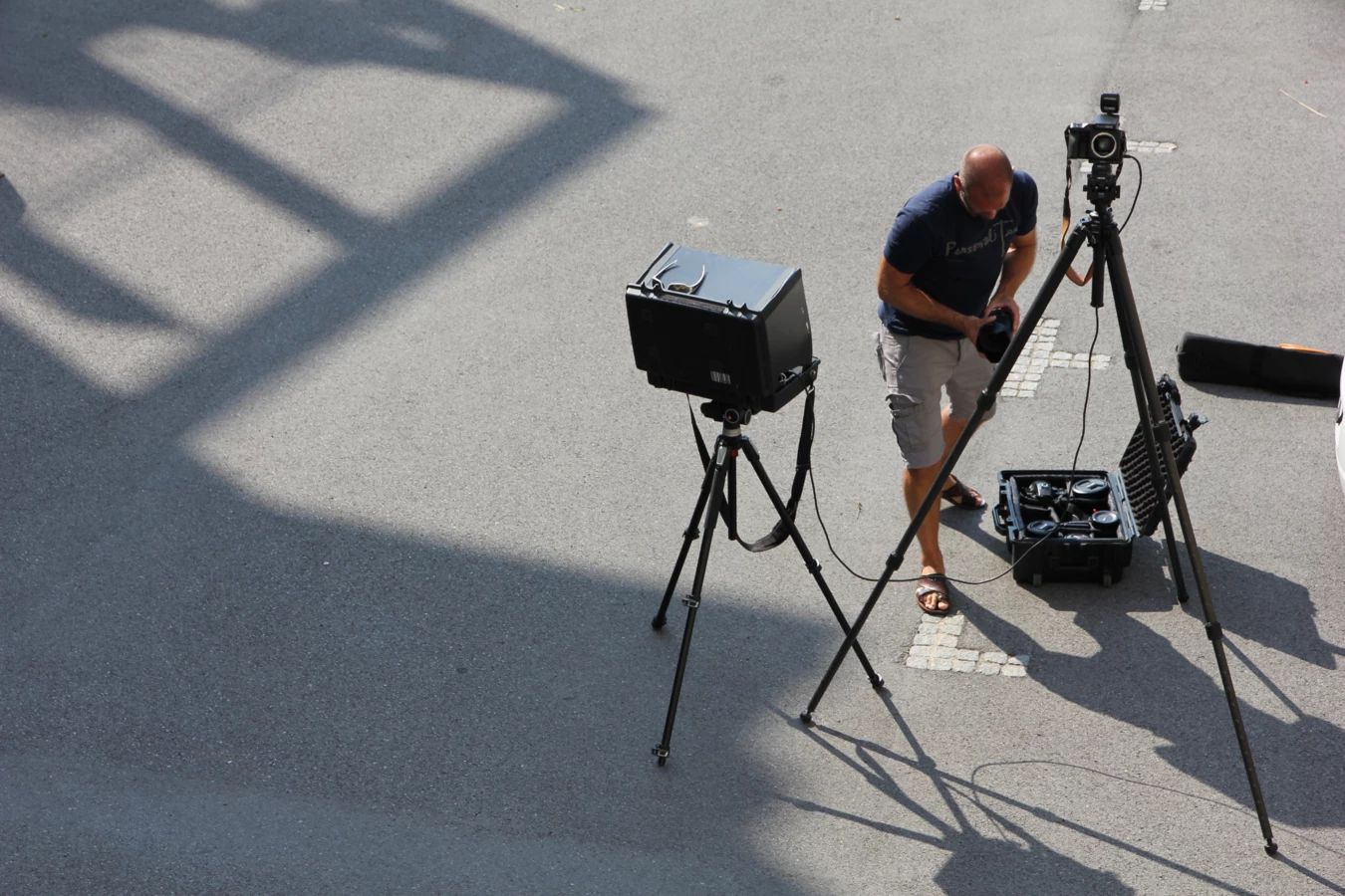 Ein Fotograf stellt seine Ausrüstung, einschließlich Kamera und Stativ, für ein Fotoshooting im Freien auf.