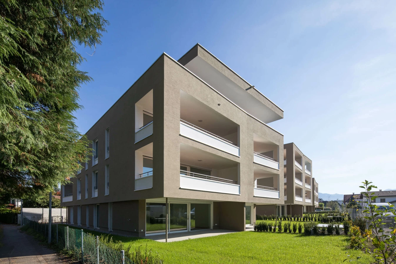 Wohnanlage Widum Lustenau 1 mit brauner Fassade und weißen Balkonen