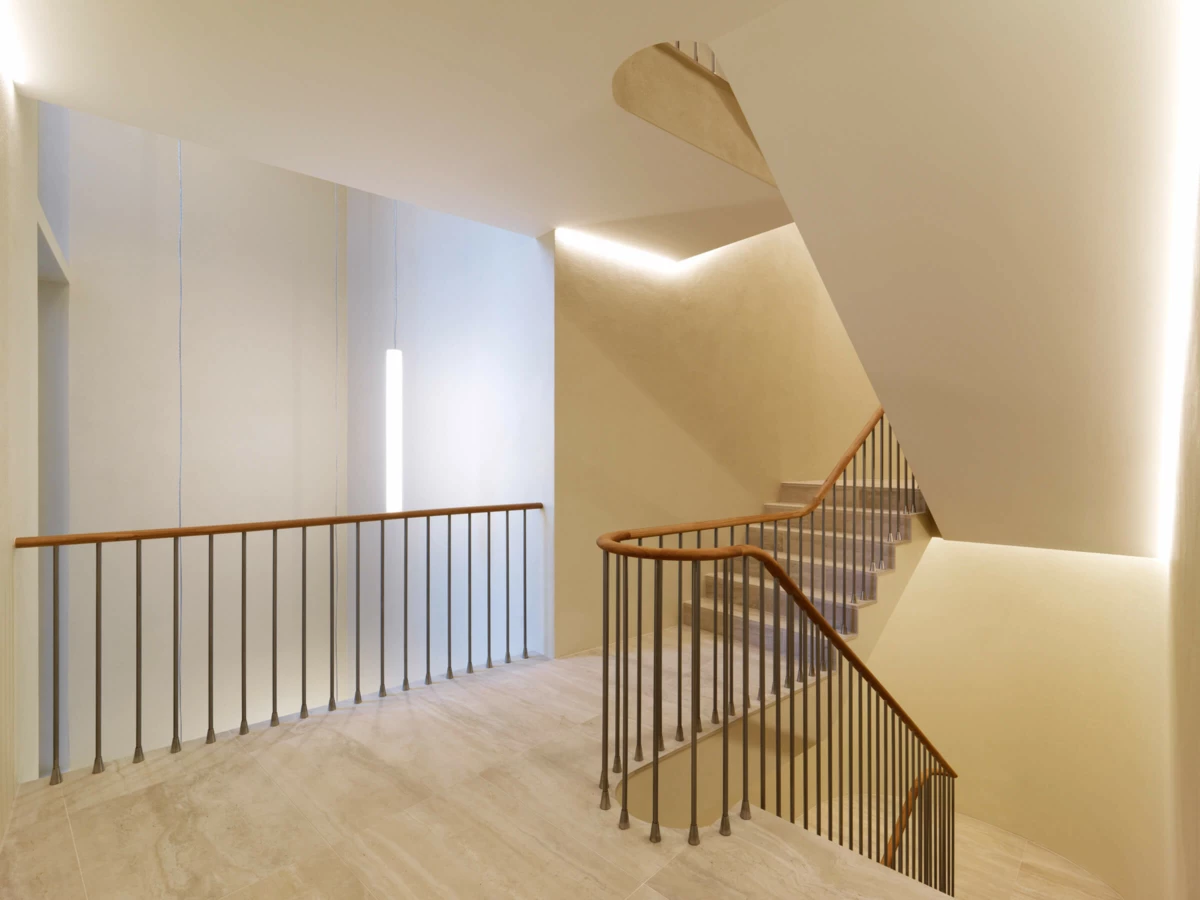 Modernes Treppenhaus mit Marmorboden, eleganten Holz-Handläufen und indirekter LED-Beleuchtung in St. Gallen (Multergasse).