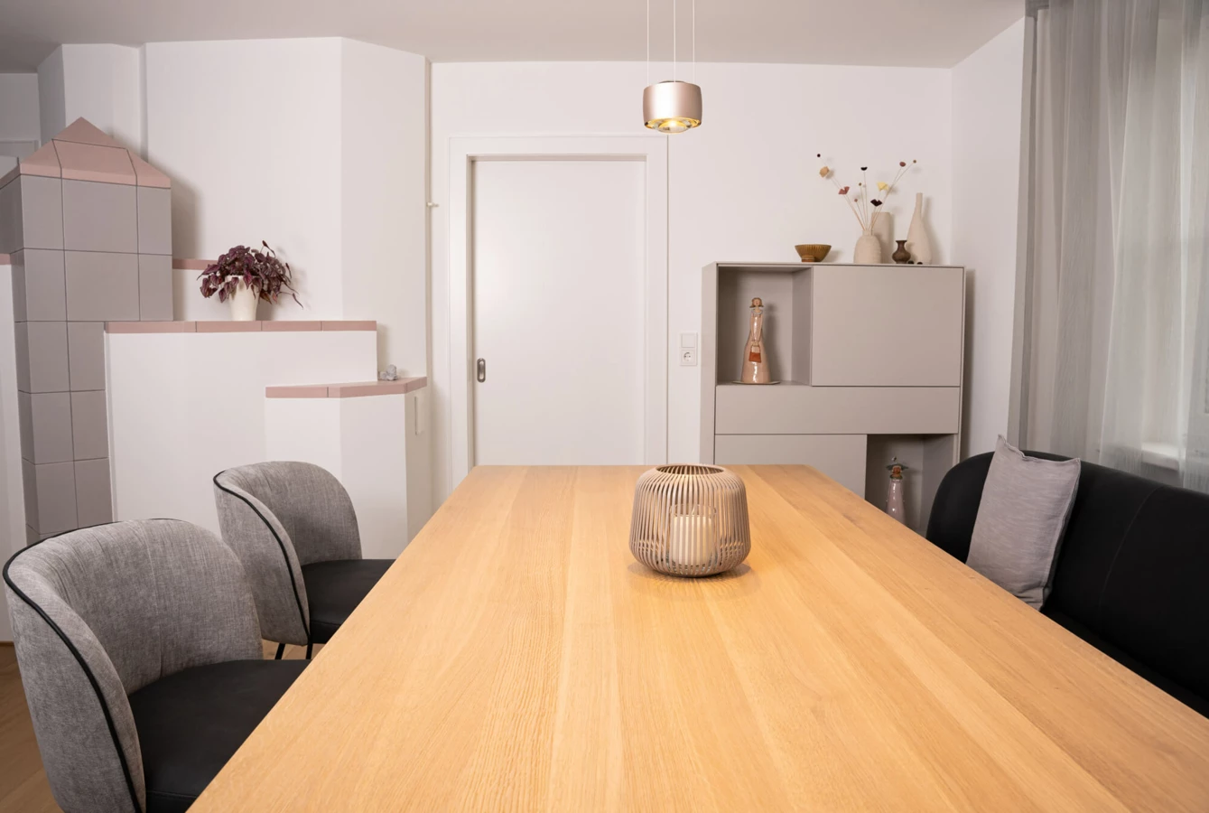 Modernes Esszimmer in einem generalsanierten Einfamilienhaus mit Holztisch, gemütlichen Stühlen und Sofa sowie stilvoller Dekoration (Generalsanierung, Bohle).