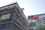 Die erste von zwei Dachgleichen: Der Firstbaum wird auf das fünfstöckige Holzgebäude aufgezogen.
